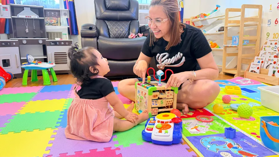 La dueña sonriendo mientras juega con una niña